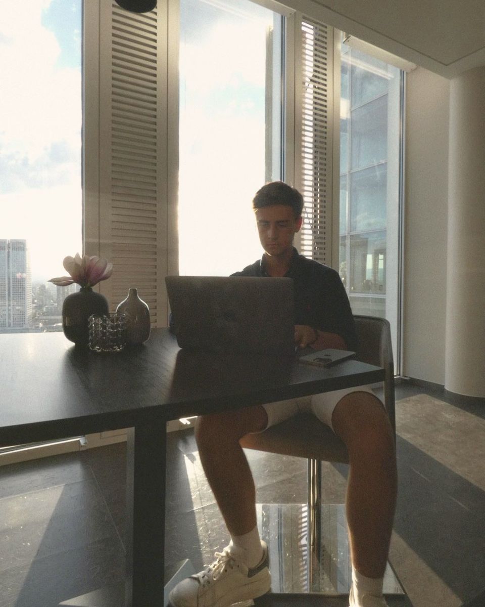 Samuel Kutger am Laptop in einem Büro hoch über der Stadt